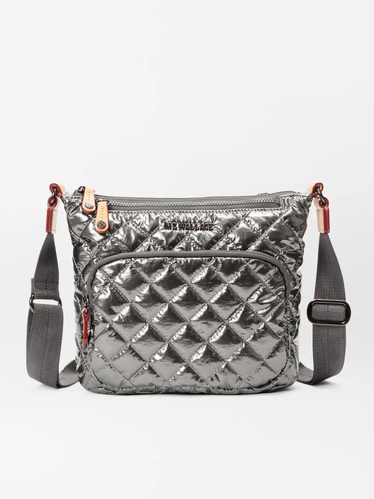 The MZ Wallace Metro Scout Deluxe in Pewter Metallic Oxford is a stunning crossbody bag crafted with Italian leather trim. It features a front pocket, zip closures, and an adjustable gray strap, making it the perfect accessory for those seeking to showcase urban elegance.