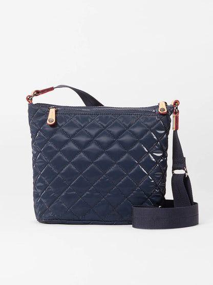 The MZ Wallace Metro Scout Deluxe in Ink Liquid Oxford is a quilted crossbody bag with gold hardware, a zip top, and an adjustable shoulder strap, shown against a plain white background.