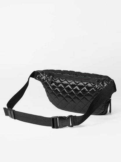 The MZ Wallace Metro Sling in Black Liquid Oxford is a hands-free bag with a stylish black quilted design, featuring an adjustable strap and a secure buckle closure against a plain white background.