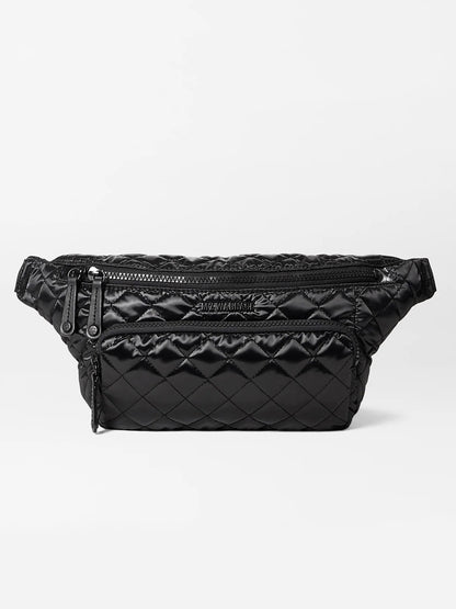 The MZ Wallace Metro Sling in Black Liquid Oxford is a quilted fanny pack with multiple zippered compartments and an adjustable strap, providing a stylish and convenient hands-free bag option.