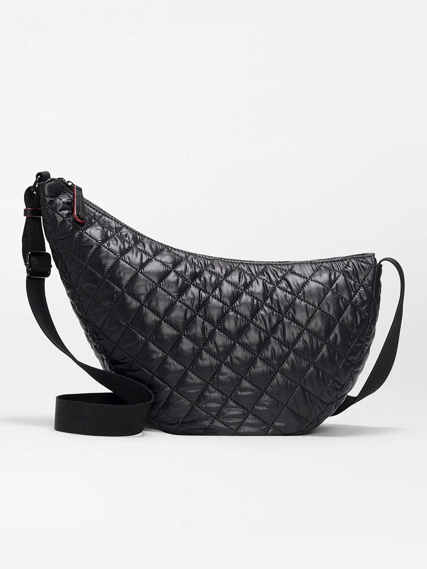 The MZ Wallace Metro Smile Bag in Black Oxford is a black quilted crescent-shaped crossbody with an adjustable nylon strap and refined Italian leather trim, shown against a plain white background.