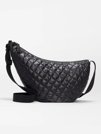 The MZ Wallace Metro Smile Bag in Black Oxford is a black quilted crescent-shaped crossbody with an adjustable nylon strap and refined Italian leather trim, shown against a plain white background.