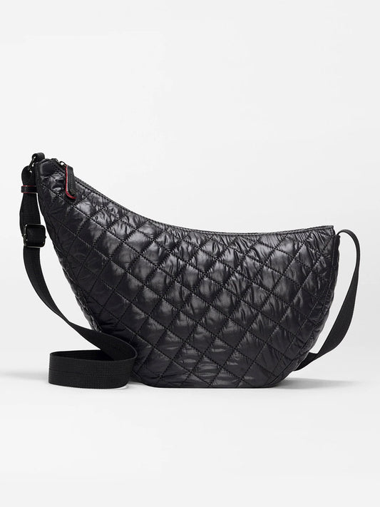 The MZ Wallace Metro Smile Bag in Black Oxford is a black quilted crescent-shaped crossbody with an adjustable nylon strap and refined Italian leather trim, shown against a plain white background.