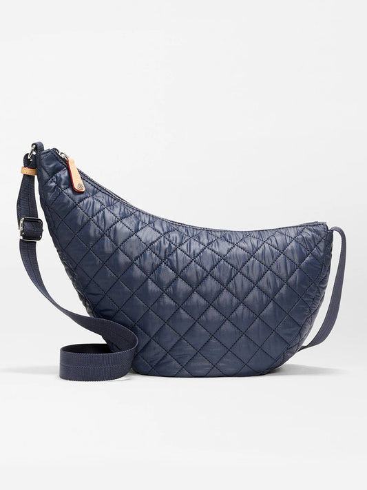 The MZ Wallace Metro Smile Bag in Dawn Oxford is a navy quilted bag with an adjustable nylon strap and zipper closure, shown against a plain white background.