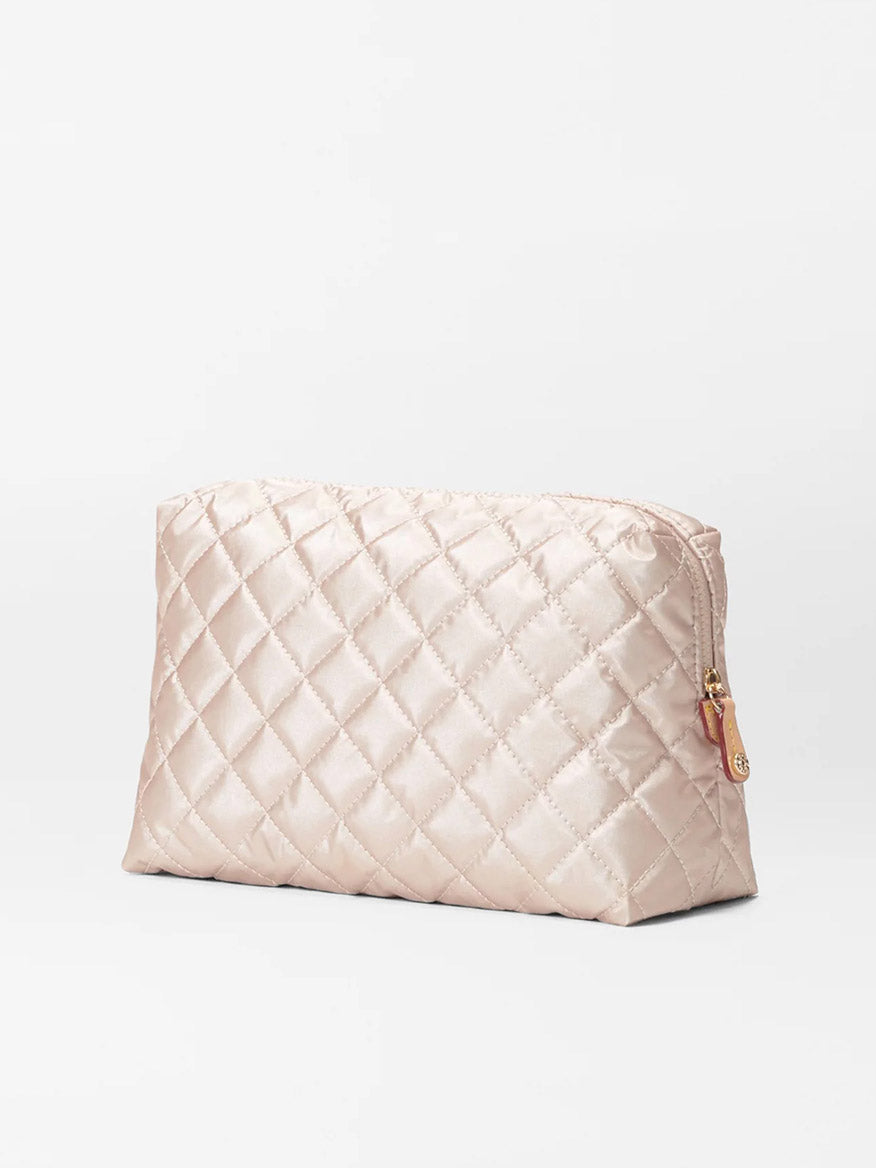 The MZ Wallace Mica Cosmetic in Pale Rose Gold Metallic Oxford, featuring a quilted design and zipper closure, crafted from luxurious Italian leather, is showcased against a plain white background.