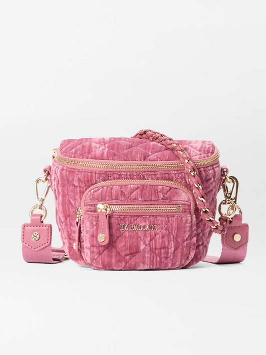 The MZ Wallace Micro Crosby Crossbody Sling in Petal Velvet features pink quilted nylon, gold hardware, front and side zip pockets, and a braided detachable strap, shown against a plain background.