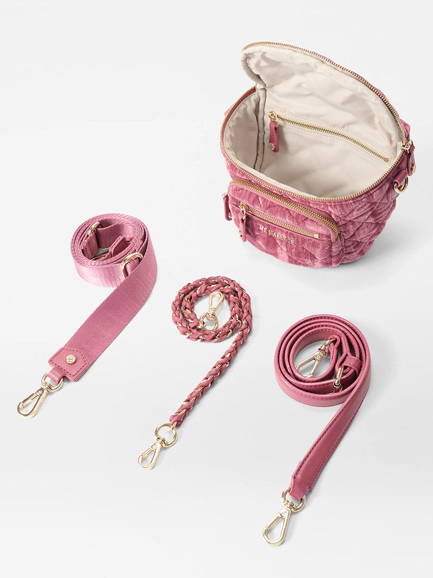 The MZ Wallace Micro Crosby Crossbody Sling in Petal Velvet is a small pink quilted nylon bag with gold zippers, a beige interior, and three detachable pink straps—ideal as a cute mini sling or crossbody for any occasion.
