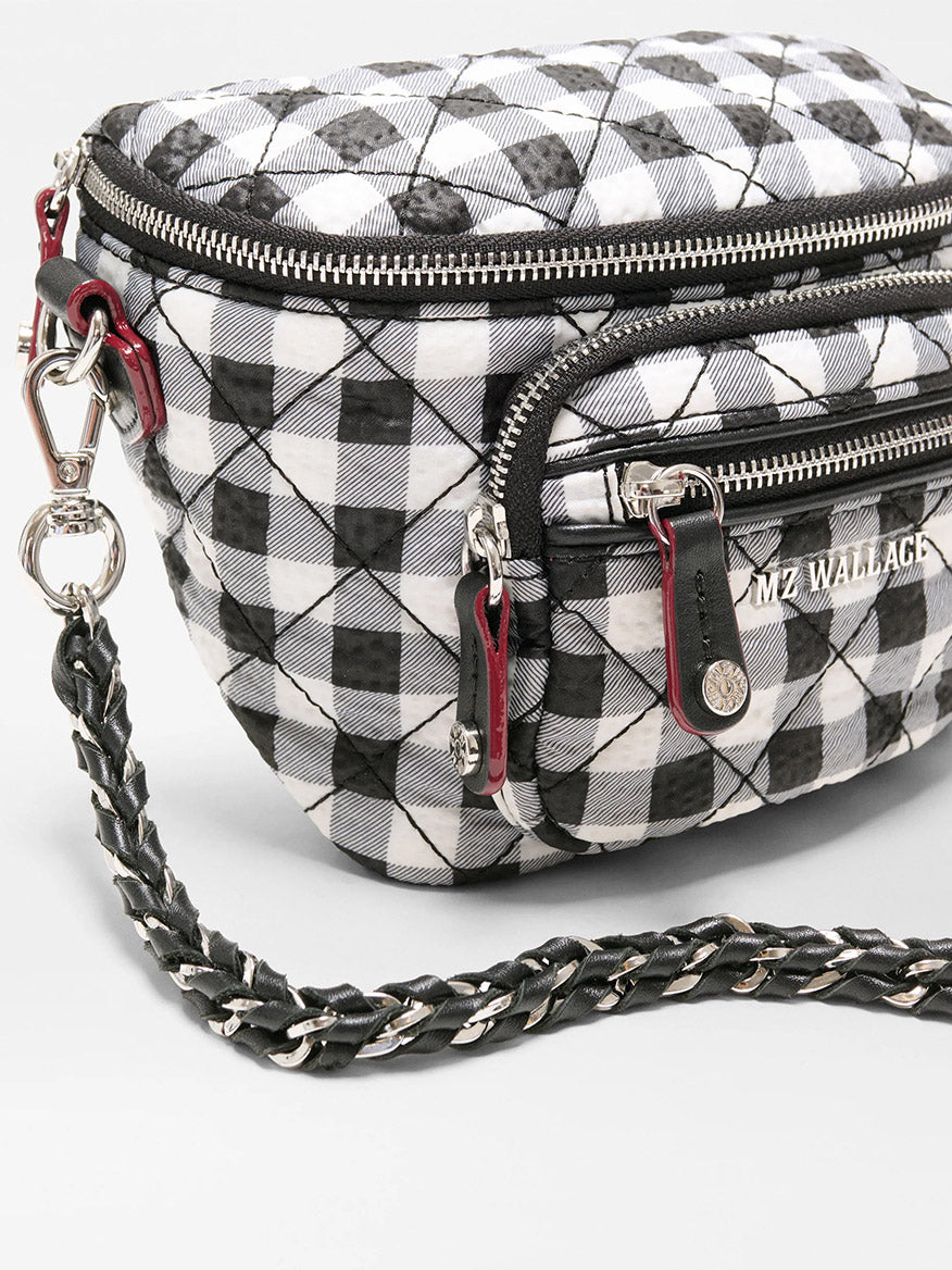 The MZ Wallace Micro Crosby Crossbody Sling in Black/White Gingham Oxford features a quilted design, braided shoulder strap, silver hardware, and multiple zippered compartments for hands-free convenience.