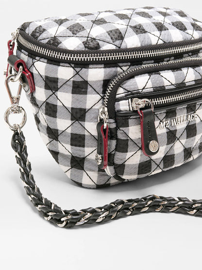 The MZ Wallace Micro Crosby Crossbody Sling in Black/White Gingham Oxford features a quilted design, braided shoulder strap, silver hardware, and multiple zippered compartments for hands-free convenience.