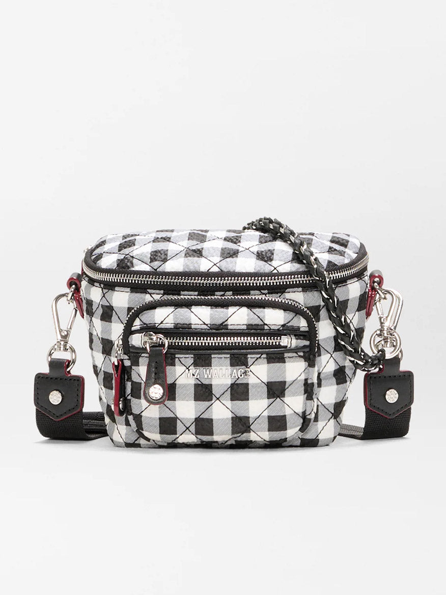 The MZ Wallace Micro Crosby Crossbody Sling in Black/White Gingham Oxford is a small recycled nylon bag featuring a checkered pattern, front zipper pockets, silver hardware, and a chain strap for hands-free convenience.