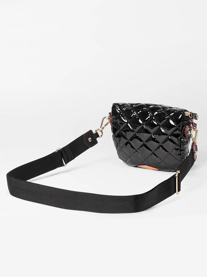 The MZ Wallace Micro Crosby Crossbody Sling in Black Lacquer Oxford is showcased on a plain white background, featuring Italian leather trim, a black quilted mini nylon design with a glossy finish, gold hardware, and an adjustable black strap.