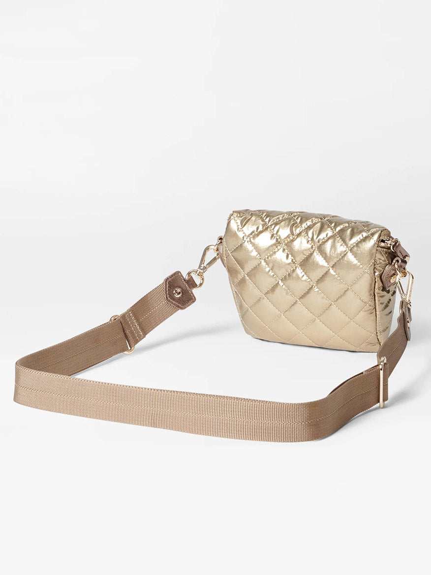 Set against a plain white background, the MZ Wallace Micro Crosby Crossbody Sling in Antique Gold Metallic Oxford boasts an adjustable brown strap and elegant gold hardware.