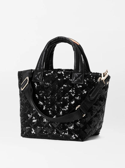 The MZ Wallace Micro Metro Tote Deluxe in Black Sequin includes two handles and a detachable crossbody strap, accented with luxurious Italian leather trim, all set against a plain background.