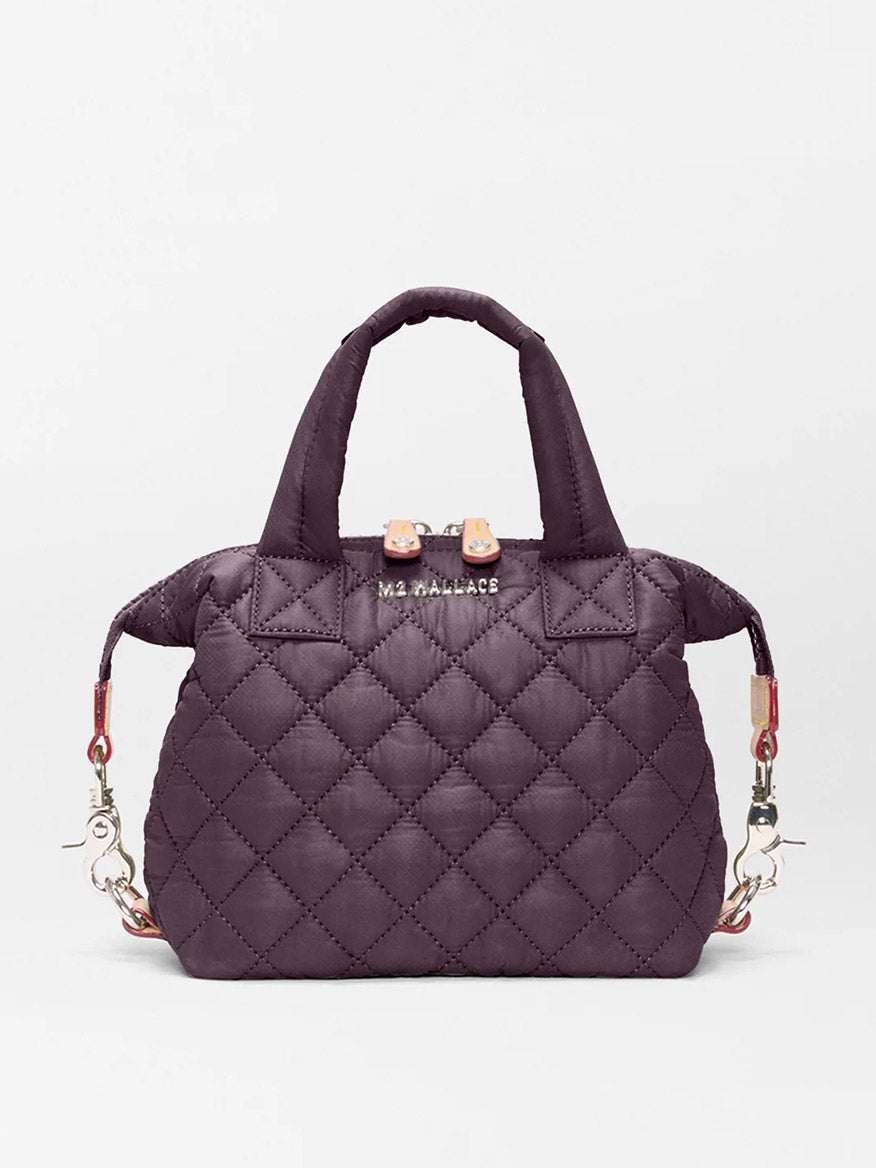 The MZ Wallace Micro Sutton in Raisin Oxford is a small quilted handbag with short handles, silver hardware, and a detachable strap—combining style and versatility in a compact crossbody design against a white background.