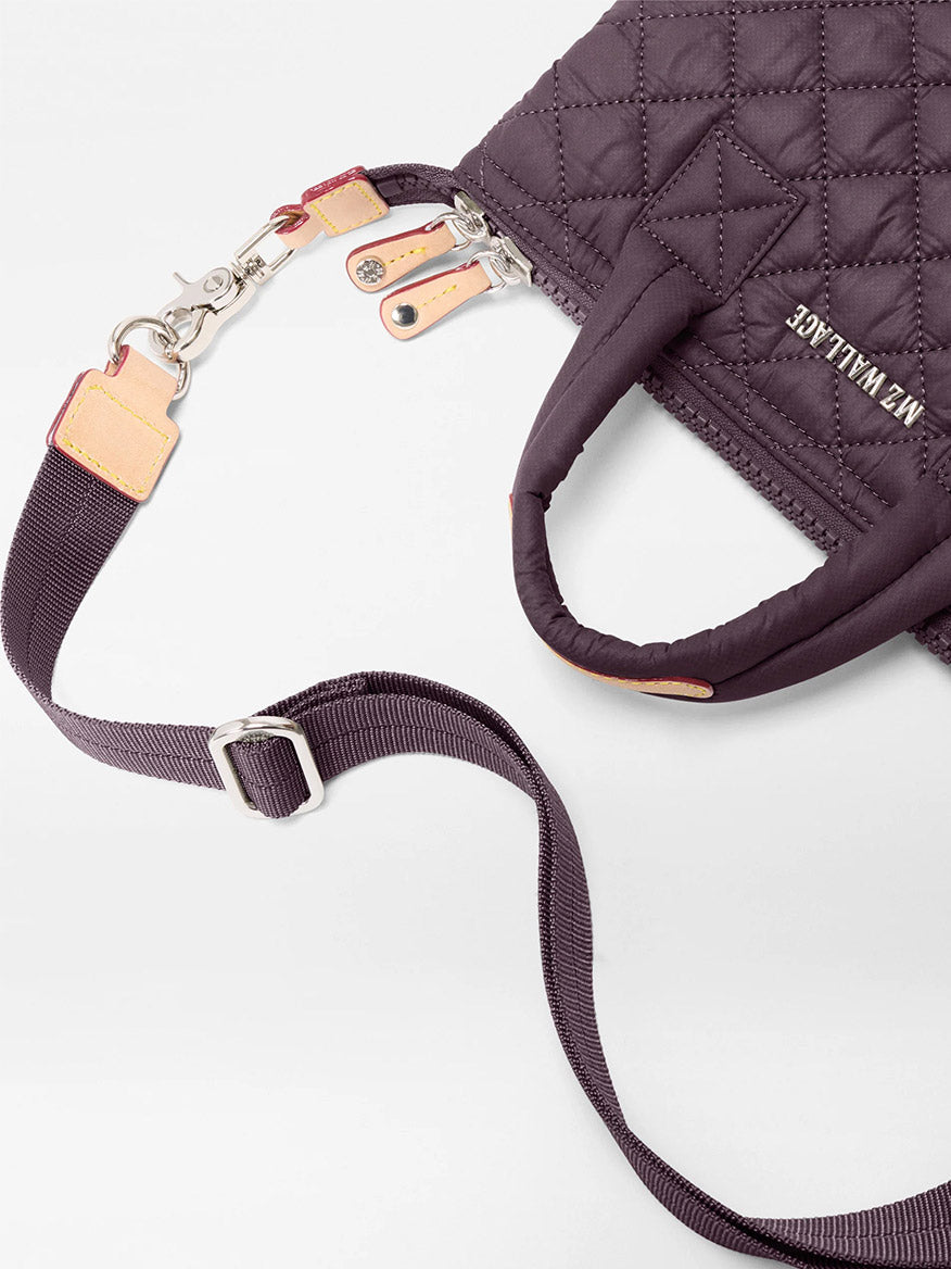 The MZ Wallace Micro Sutton in Raisin Oxford is a compact purple quilted crossbody with a detachable strap, metal hardware, and the "MZ WALLACE" logo on recycled nylon.