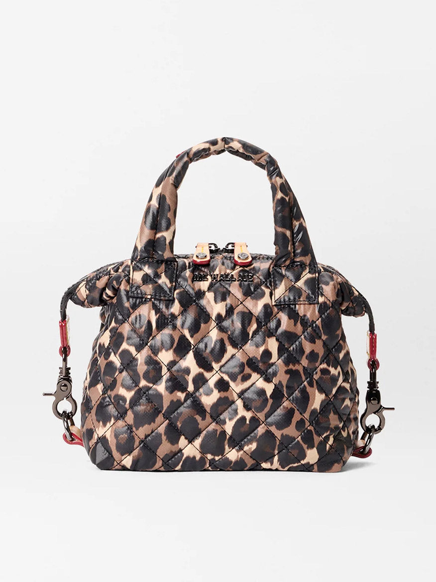 The MZ Wallace Micro Sutton in Leopard Oxford features a brown and black leopard print, short handles, and a detachable shoulder strap. Made from recycled oxford material, it can be used as a foldable crossbody for versatile wear.