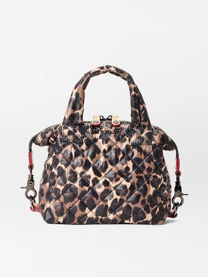 The MZ Wallace Micro Sutton in Leopard Oxford features a brown and black leopard print, short handles, and a detachable shoulder strap. Made from recycled oxford material, it can be used as a foldable crossbody for versatile wear.