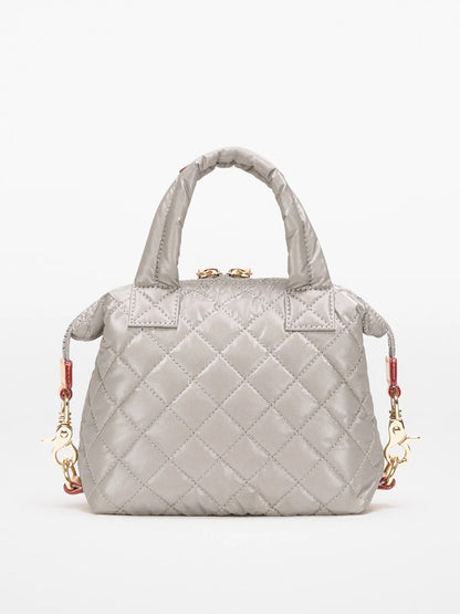 The MZ Wallace Micro Sutton in Sable Pearl Metallic Oxford is a small quilted gray handbag with short handles, gold hardware, and detachable clasps for an optional crossbody strap, shown against a plain white background.