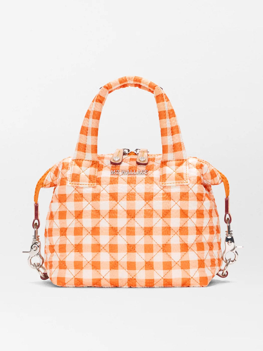 The MZ Wallace Micro Sutton in Sunset Orange Gingham Oxford is a quilted handbag made from recycled Oxford nylon, featuring top handles, silver hardware, zip closure, and an adjustable crossbody strap with detachable clips.
