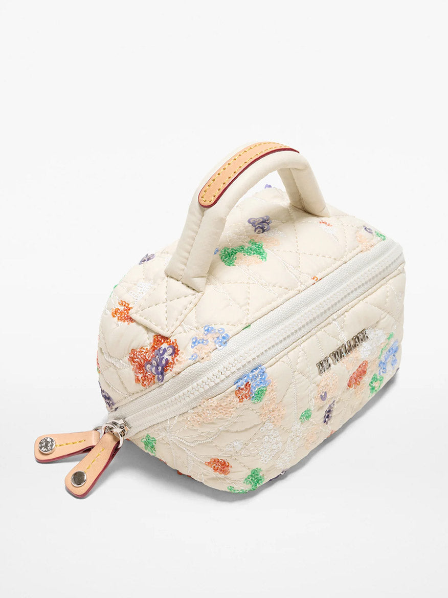 The MZ Wallace Mini Accordion Jewelry Case in Eden Sequin Oxford features a quilted design, top handle, floral embroidery, interior pockets, zip closure, and side branding.