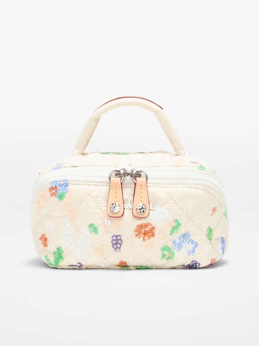 The MZ Wallace Mini Accordion Jewelry Case in Eden Sequin Oxford is a small, rectangular, cream-colored quilted bag with vibrant embroidery, a top handle, dual zippers, and multiple interior pockets for easy organization.