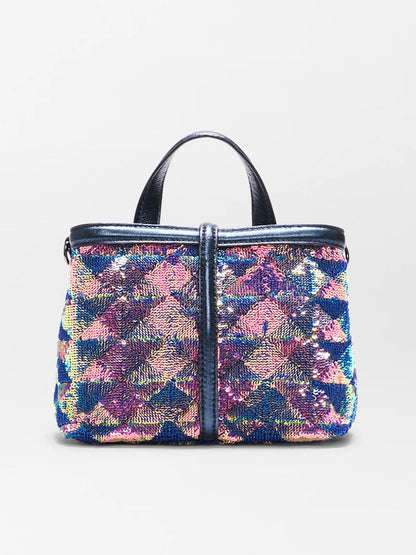 The MZ Wallace Mini Astor Top Handle in Aurora Sequin features black handles and a geometric pattern of blue, pink, and purple sequins on a white background.
