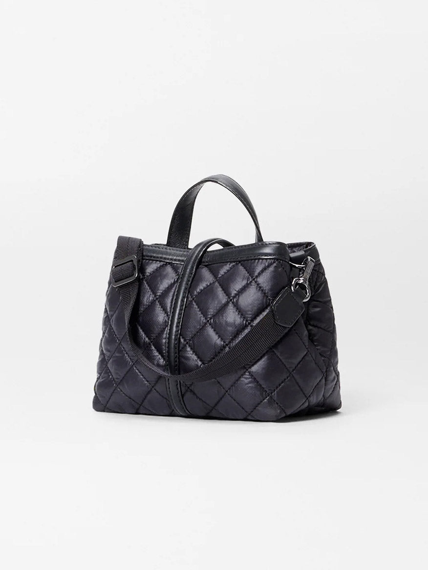 From the MZ Wallace Mini Astor Top Handle in Black Oxford collection, this black quilted handbag boasts short handles and an adjustable Italian leather strap on a plain background.