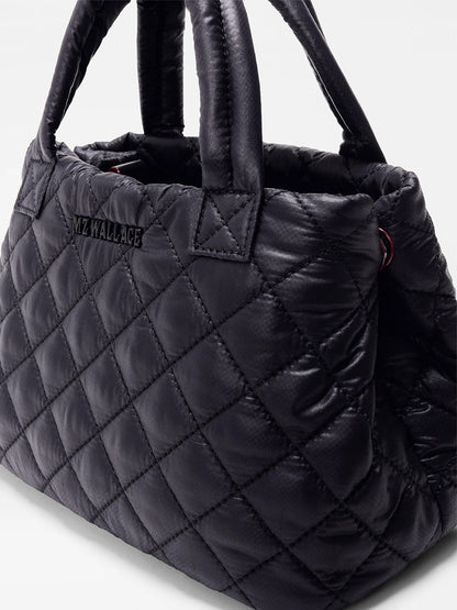 The MZ Wallace Mini City Tote in Black Oxford is a quilted black mini tote made from REC nylon, with short handles and "MZ WALLACE" stitched on the side.