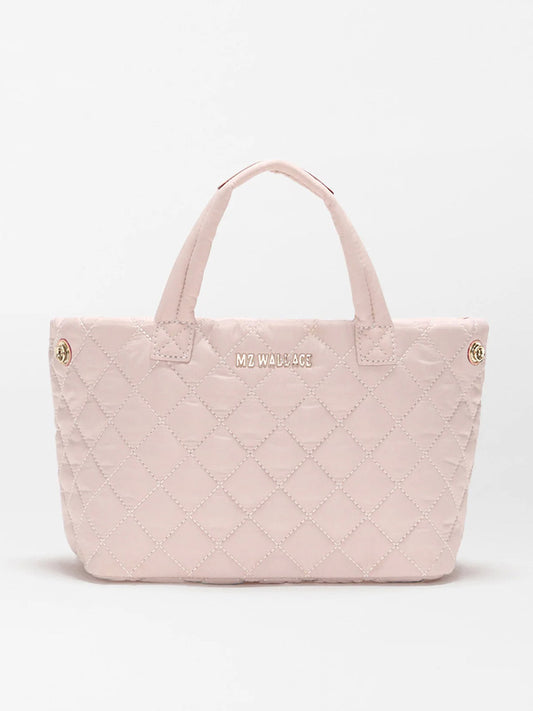 The MZ Wallace Mini Metro City Tote in City Pink Oxford is a light pink quilted mini tote made from REC nylon, with two short handles, gold-tone hardware, and the "MZ WALLACE" logo on the front.