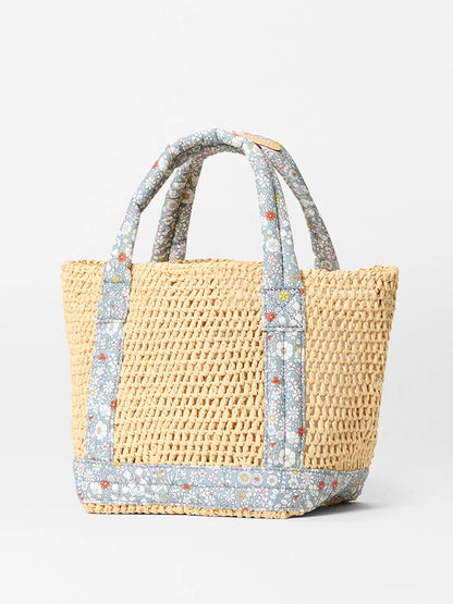 The MZ Wallace Mini Crochet Tote in Crochet/June's Meadow Liberty Fabric showcases boho flair with blue floral fabric handles and trim, set against a plain white background.