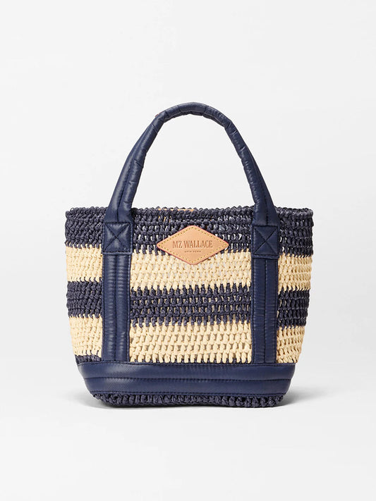 The MZ Wallace Mini Crochet Tote in Dawn/Natural Stripe features navy and natural crochet stripes, denim-trimmed navy handles, and a tan leather logo patch on the front.