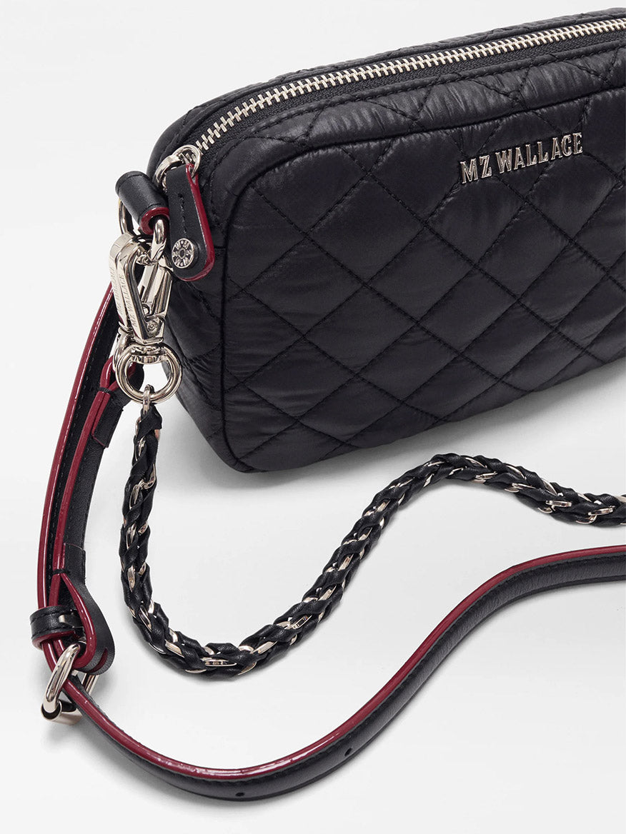 Close-up of the MZ Wallace Mini Crosby Crossbody II in Black Oxford, featuring Italian leather trim, a leather and chain strap, silver hardware, and red detailing.