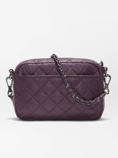 The MZ Wallace Mini Crosby Crossbody II in Raisin Oxford is a compact quilted bag made from recycled Oxford nylon, featuring both chain and leather details on its detachable strap, and is shown against a plain white background.