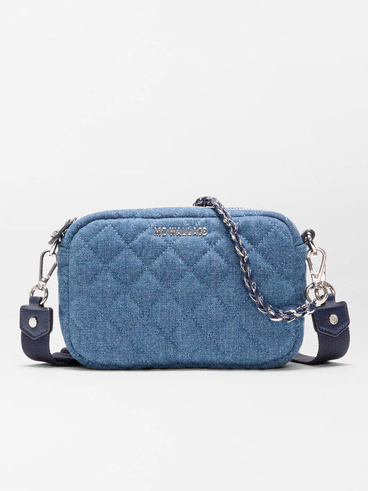 The MZ Wallace Mini Crosby Crossbody II in True Blue Denim is a small blue quilted bag with a detachable chain strap and silver hardware, shown against a plain background.