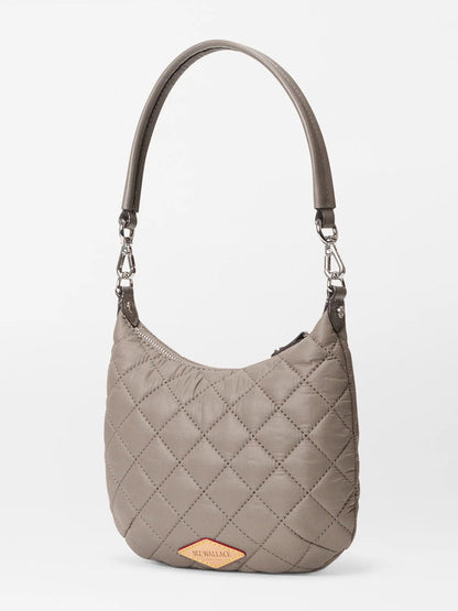 The MZ Wallace Mini Crosby Sienna in Morning Dove Oxford is a taupe quilted satchel with a short handle, silver hardware, and a tan tag featuring the brand’s logo—perfect for everyday use.
