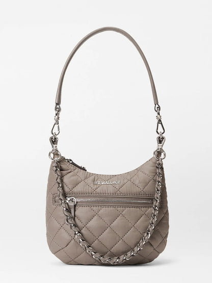 The MZ Wallace Mini Crosby Sienna in Morning Dove Oxford features a taupe quilted design, front zipper pocket, chain and leather strap, and logo on the front—making it a stylishly versatile everyday shoulder satchel.