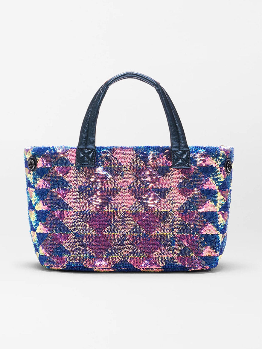 The MZ Wallace Mini Metro City Tote in Aurora Sequin is a medium-sized handbag with black handles, featuring a vibrant geometric pattern of blue, pink, yellow, and purple sequins.