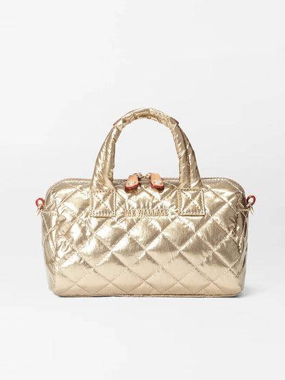 The MZ Wallace Mini Metro Satchel in Antique Gold Metallic Oxford is a quilted crossbody bag made from natural Italian leather, showcasing short handles, a detachable strap, and a secure zipper closure, all set against a white background.