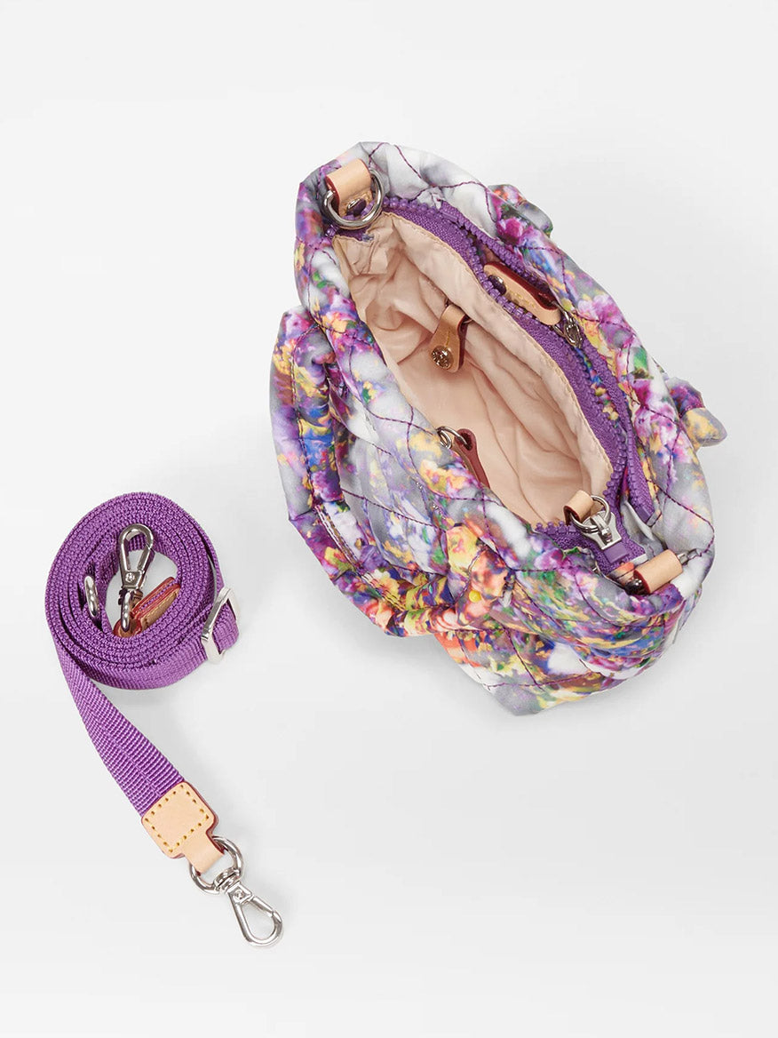 Top view of an open, floral-patterned MZ Wallace Petite Metro Tote Deluxe in Cherry Blossom Oxford with a purple, adjustable crossbody strap and a matching detachable leash, displayed on a white background.