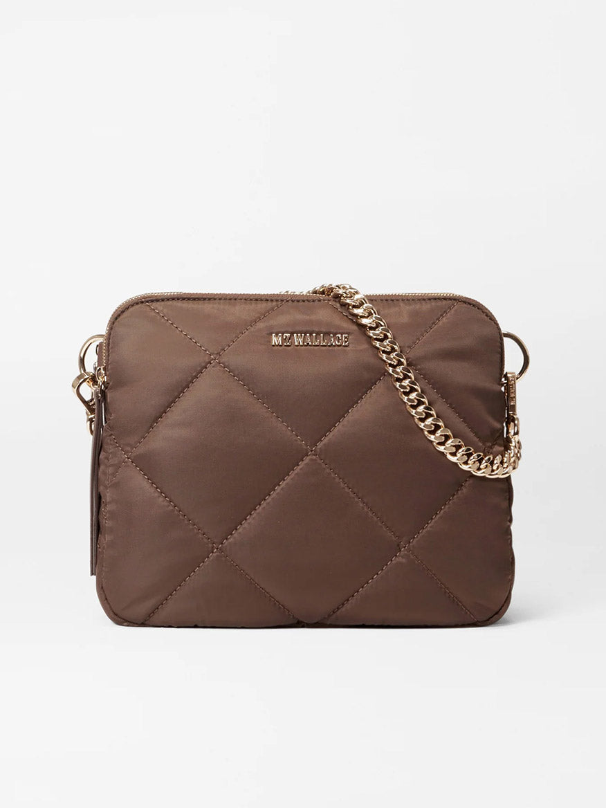 The MZ Wallace Quilted Madison Crossbody in Walnut Bedford, crafted from recycled nylon, features a gold detachable chain strap and a small logo on the front.