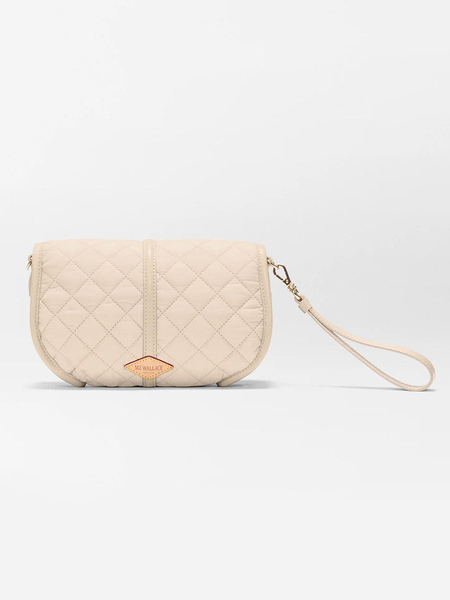 The MZ Wallace Small Astor Convertible Clutch in Buff Oxford is a beige quilted nylon wristlet purse with a detachable Italian leather strap and a small front leather logo patch, shown on a plain white background.
