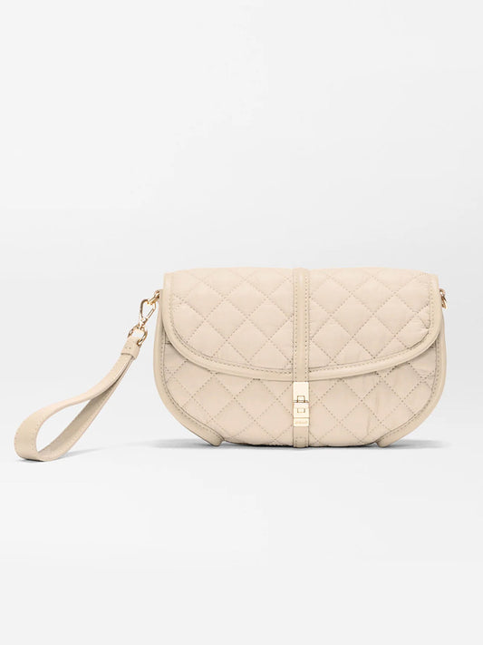 The MZ Wallace Small Astor Convertible Clutch in Buff Oxford features beige quilted fabric, gold-tone hardware, a flap closure, and a detachable Italian leather strap, shown against a plain white background.