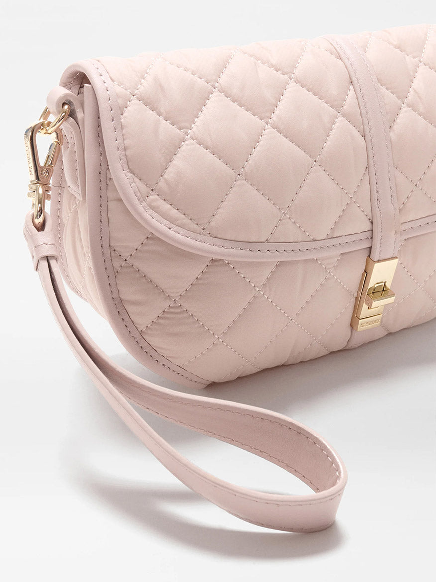 The MZ Wallace Small Astor Convertible Clutch in City Pink Oxford features quilted fabric, a gold clasp, Italian leather trim, and a detachable strap.