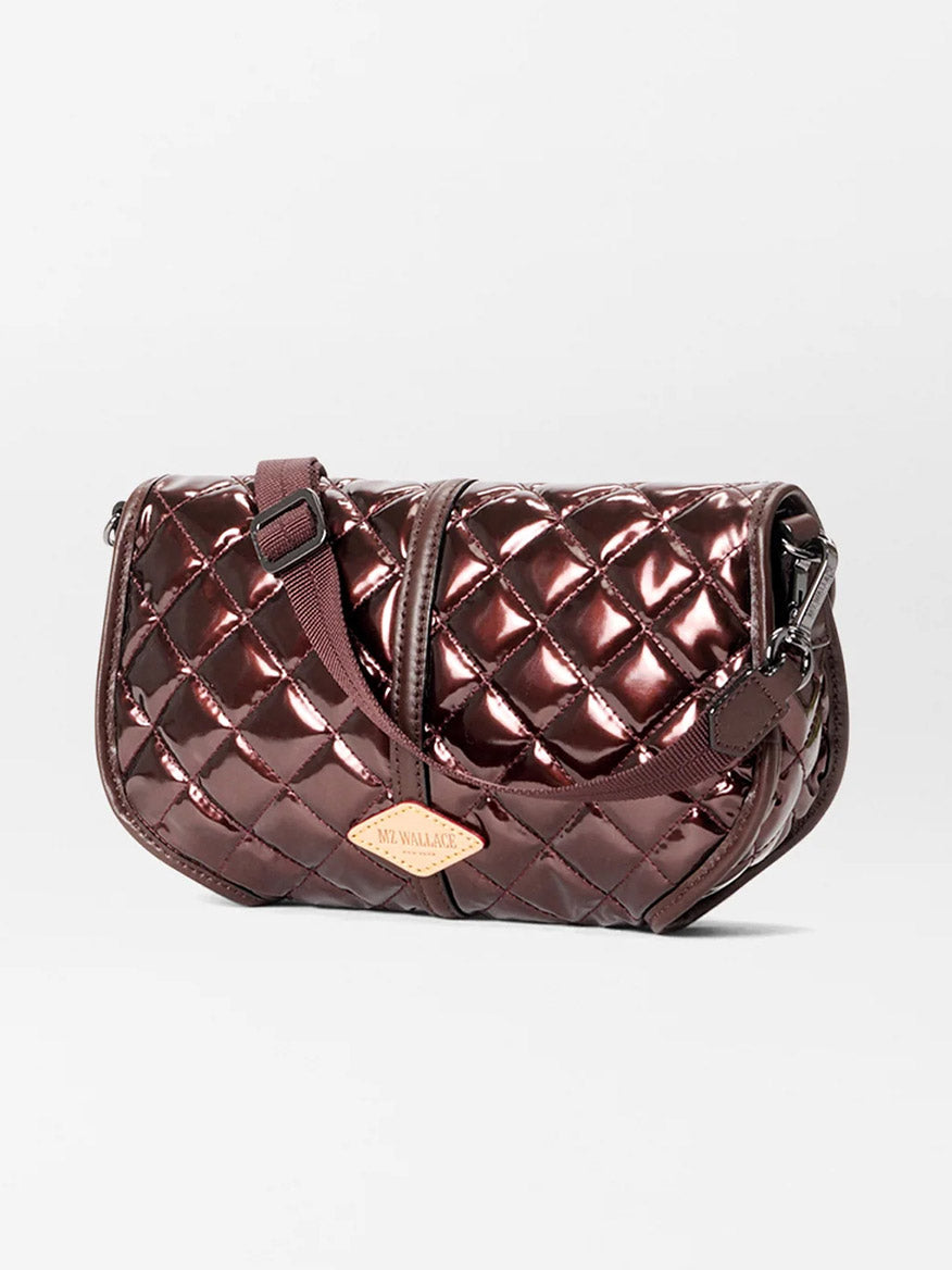 The MZ Wallace Small Astor Convertible Clutch in Bordeaux Lacquer Oxford features a quilted metallic burgundy finish, adjustable strap, Italian leather trim, and a small logo tag on the front.