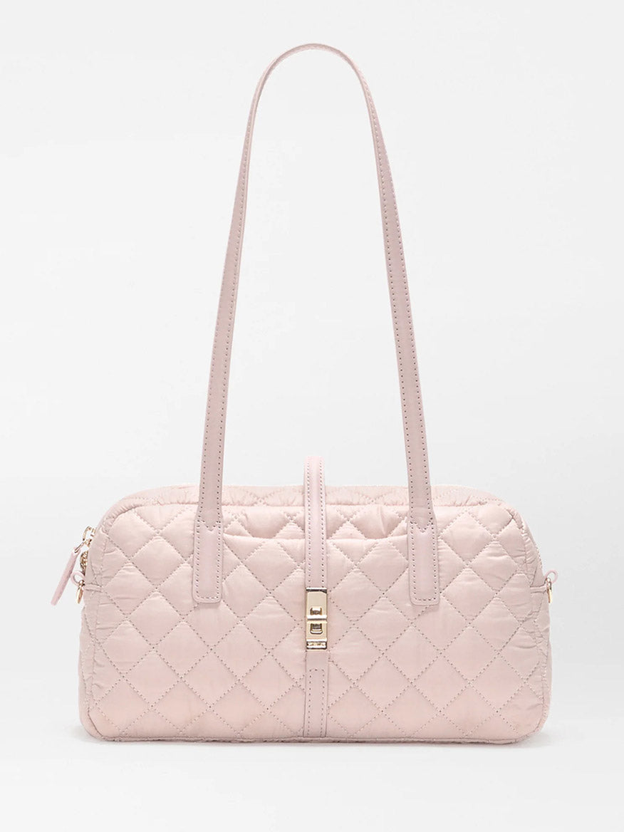 The MZ Wallace Small Astor Satchel in City Pink Oxford is a light pink quilted nylon bag with Italian leather trim, two long shoulder straps, and a gold clasp, shown against a plain white background.