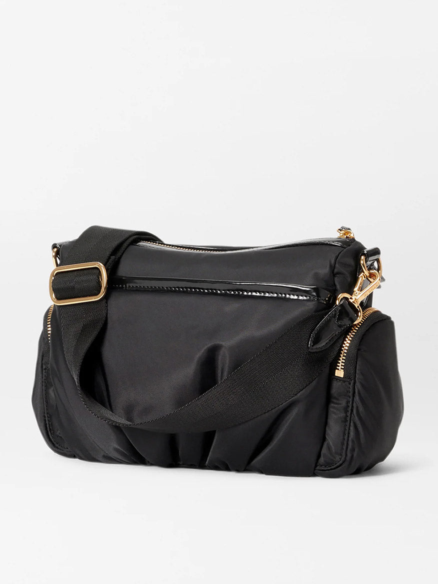 A MZ Wallace Small Chelsea Crossbody in Black Bedford with a gold buckle. Additionally, it features an adjustable crossbody strap for convenient carrying.