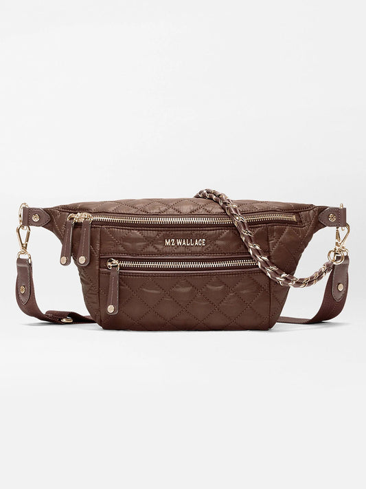 MZ Wallace Small Crosby Sling Bag in Walnut Oxford, a brown quilted recycled nylon sling bag with gold hardware, a zippered front pocket, and an adjustable chain-link strap.