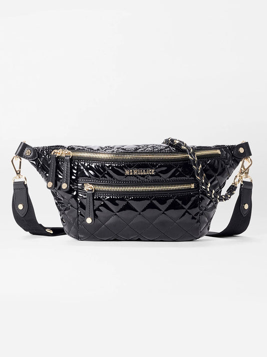 The MZ Wallace Small Crosby Sling Bag in Black Lacquer Oxford features gold hardware, multiple compartments, and an adjustable strap—ideal for chic everyday style.