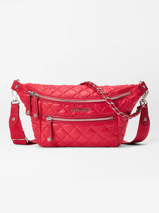 The MZ Wallace Small Crosby Sling Bag in Apple Oxford is a red quilted crossbody with silver zippers, braided handle, adjustable strap, and front zip pockets, shown on a white background.