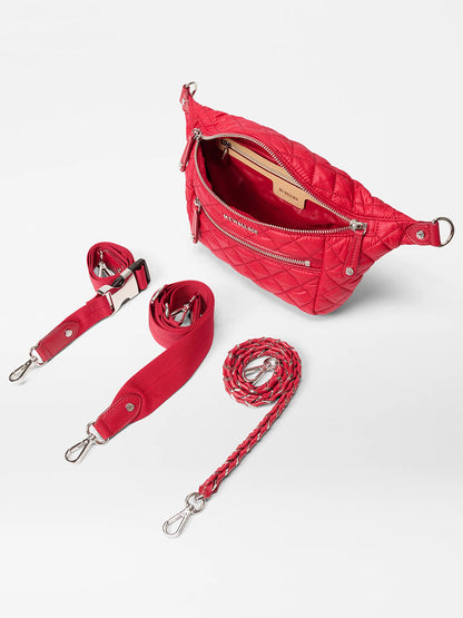 The MZ Wallace Small Crosby Sling Bag in Apple Oxford is a red quilted crossbody with a zip main compartment, front zip pocket, and three detachable red straps with metal clips, shown on a white background.